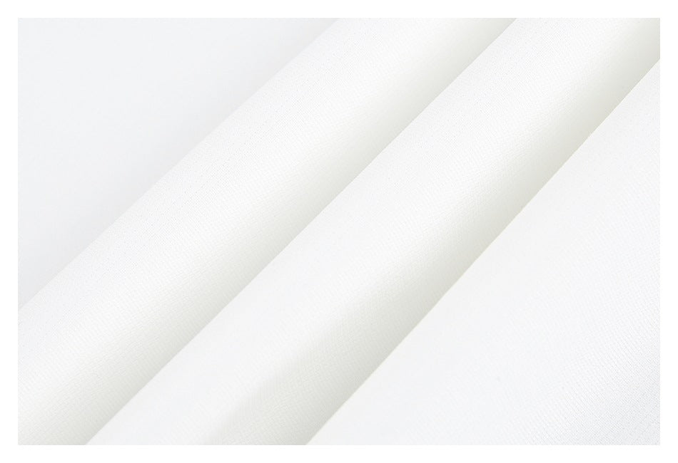 Close-up of white garment fabric folded diagonally, showing its fine textured surface.