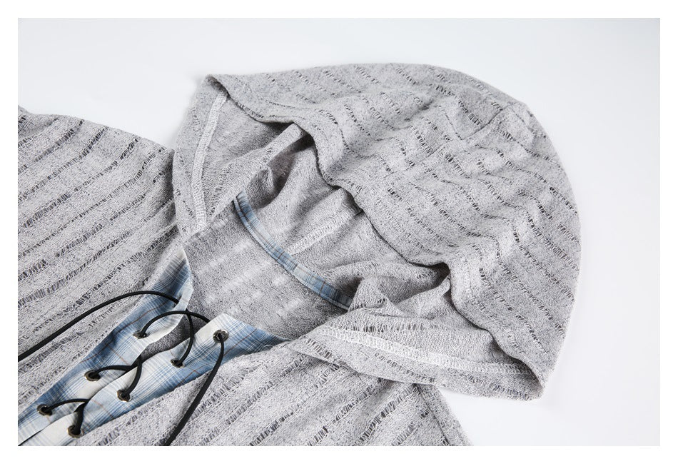 Close-up of the gray hood and lace-up neckline, showing blue plaid lining and textured fabric.
