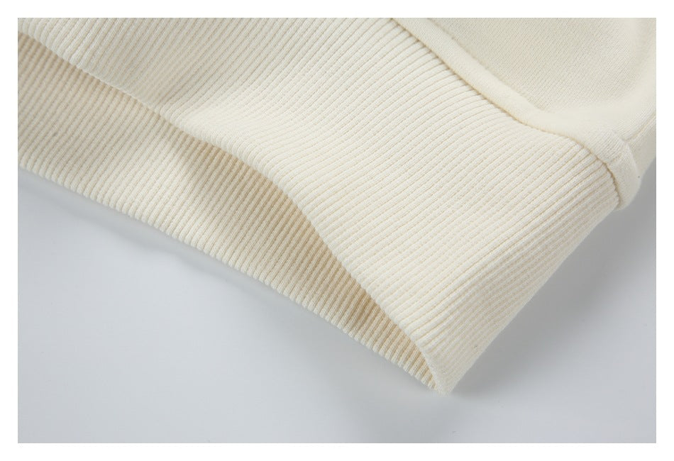 Close-up of the wide ribbed cream hem and seam on a garment.