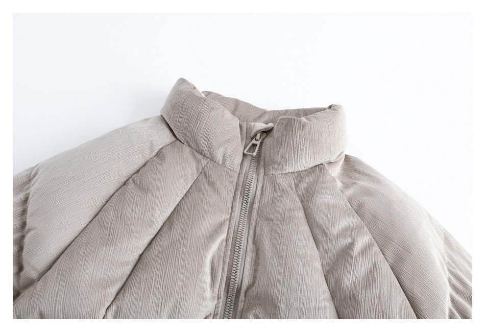 Close view of a light taupe jacket front with a tall padded collar, center zipper, and raglan seams.