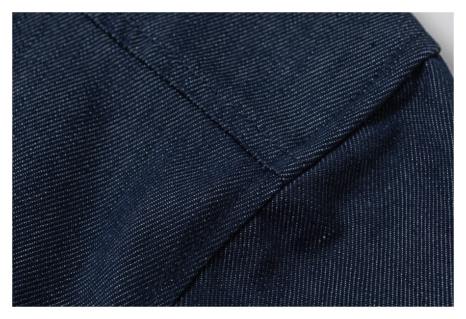 Close-up of intersecting stitched seams on textured dark navy fabric.