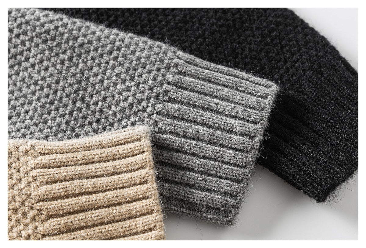 Close-up of gray, beige, and black knit sweater cuffs showing textured stitches and ribbed edges.