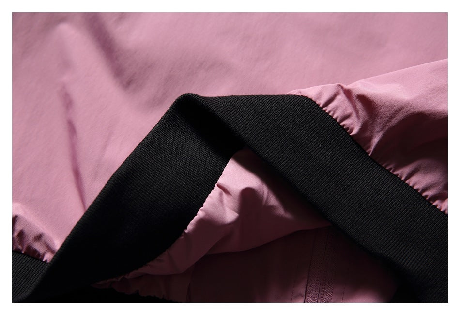 Close-up of a black ribbed elastic band crossing pink garment fabric.