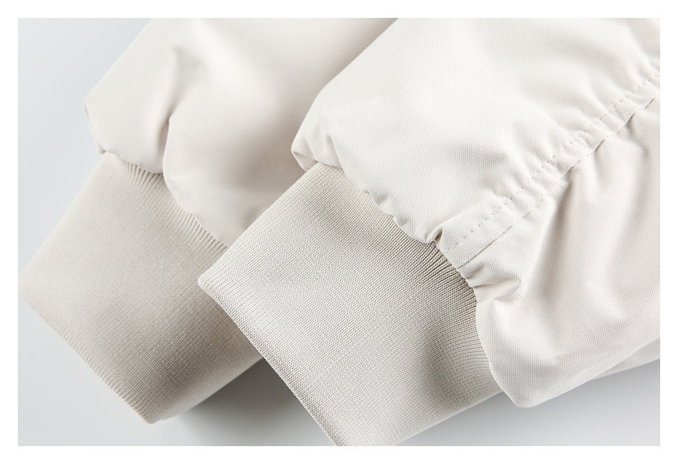 Close-up of the ivory jacket's gathered sleeve ends and wide ribbed cuffs.