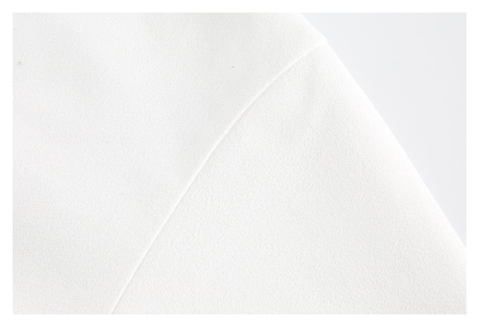 Macro view of a white garment panel and curved seam.