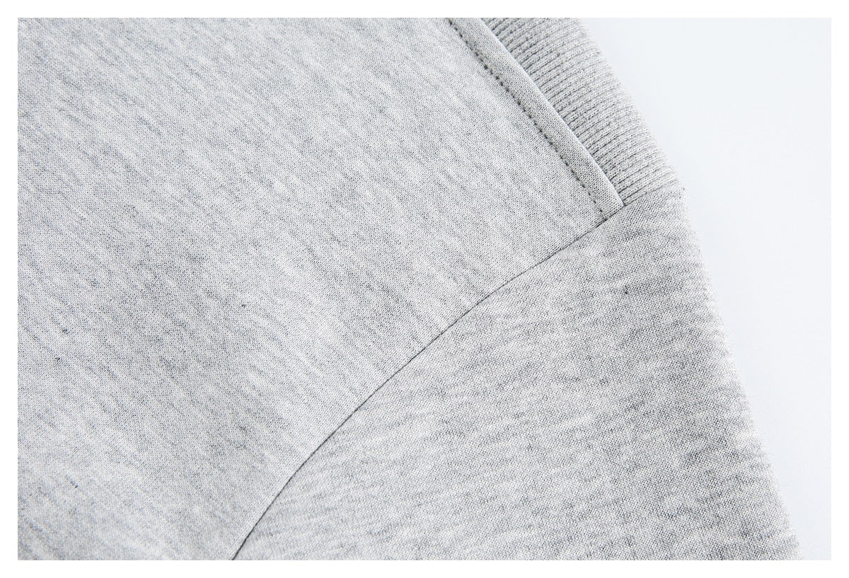 Close-up of a heather gray garment's shoulder and sleeve seam.