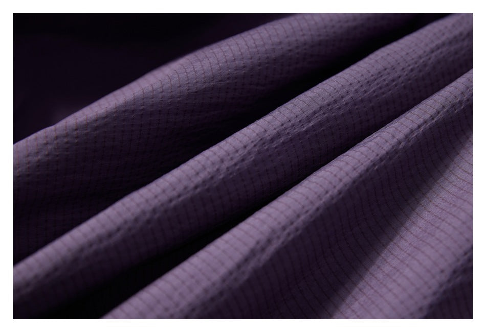 Close-up of draped dark purple fabric with a fine grid pattern.