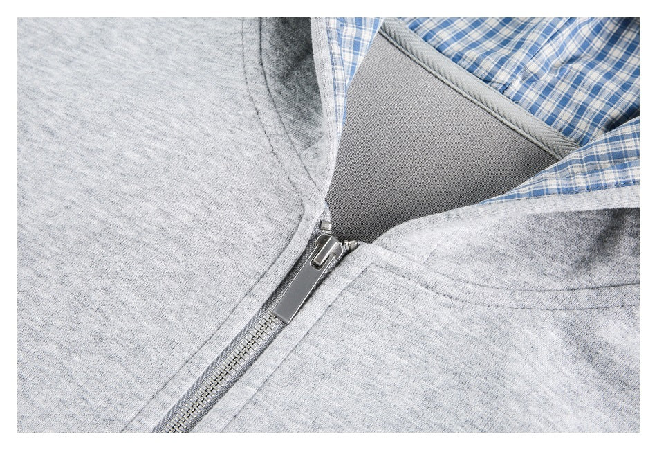 Close-up of the gray hoodie’s metal zipper, collar, and blue-and-white plaid hood lining.