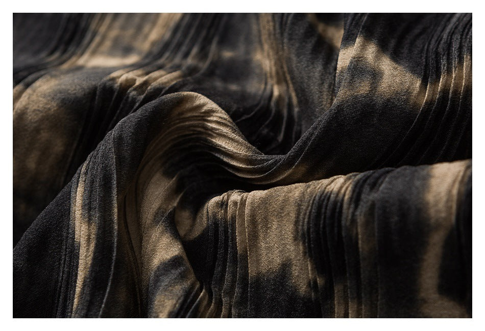 Close-up of dark charcoal and bronze-toned fabric gathered into soft folds.