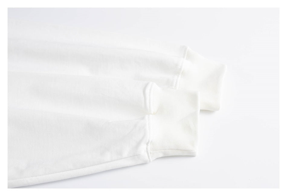 Close-up of two white shirt sleeve cuffs and their stitching.