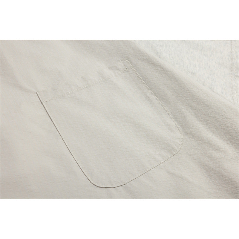Close-up of a large, rounded patch pocket sewn onto the light beige front of a T-shirt.