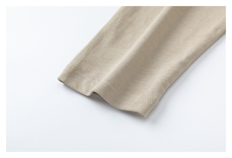 Close-up of a beige sleeve hem with visible stitching.