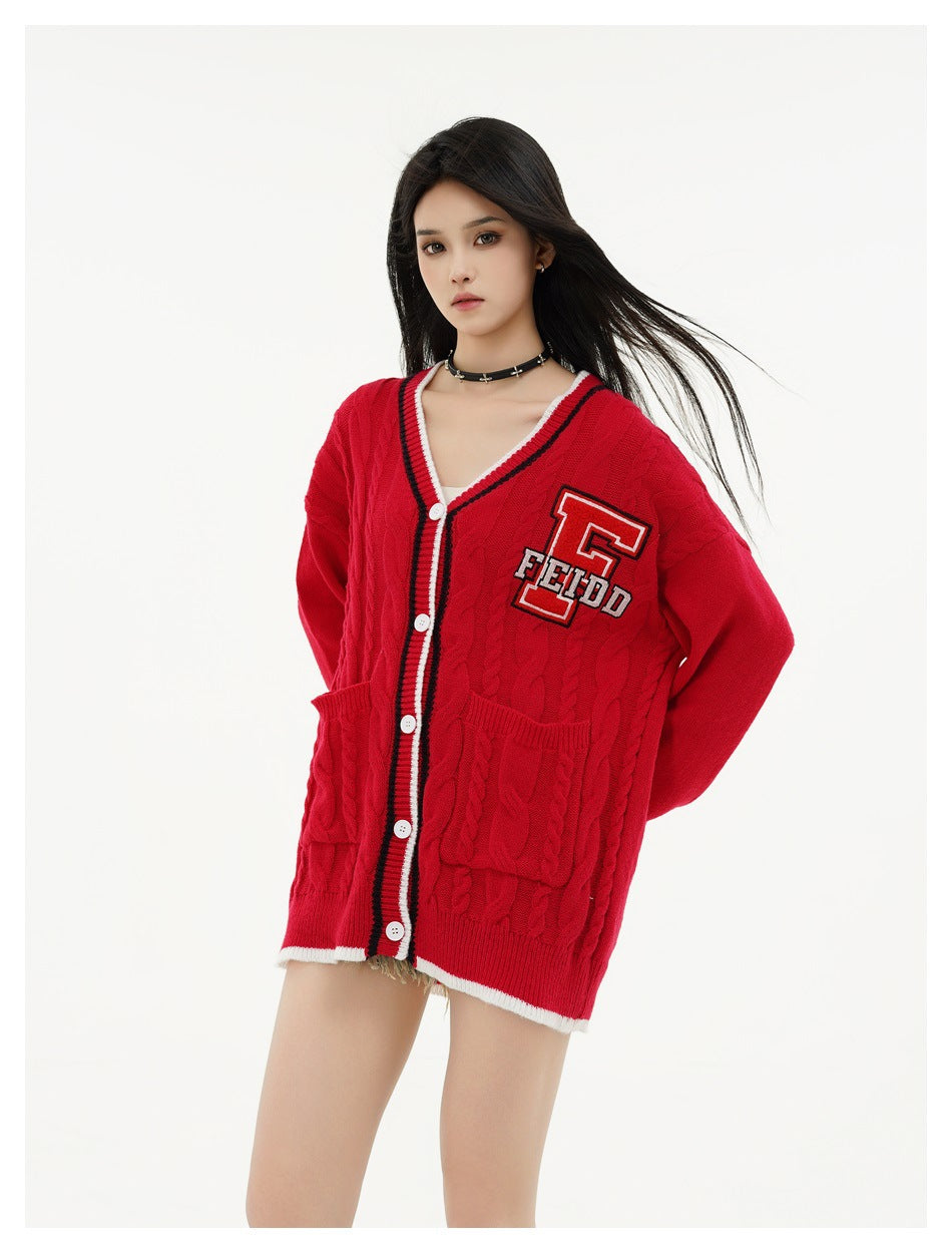 Model wearing an oversized red cable-knit cardigan with white-trimmed hem, front pockets and a letter F chest patch