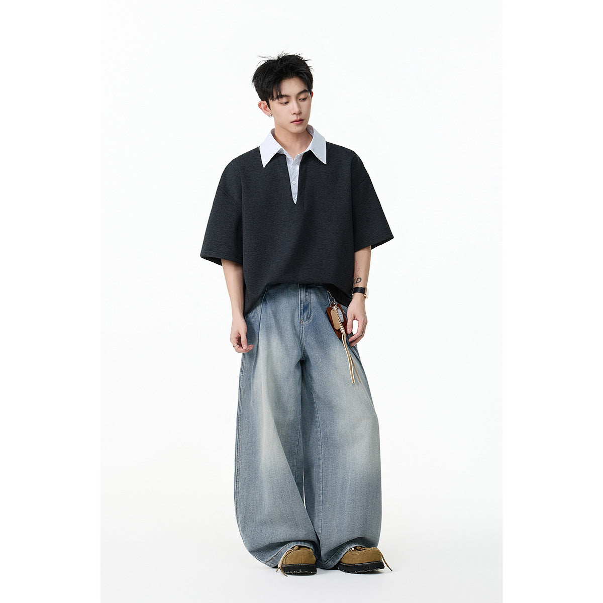 Model wearing a charcoal oversized short-sleeve shirt with a white pointed collar and light blue wide-leg jeans.