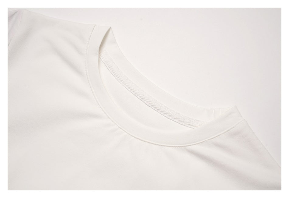 Close-up of the white crew neckline and shoulder seam.
