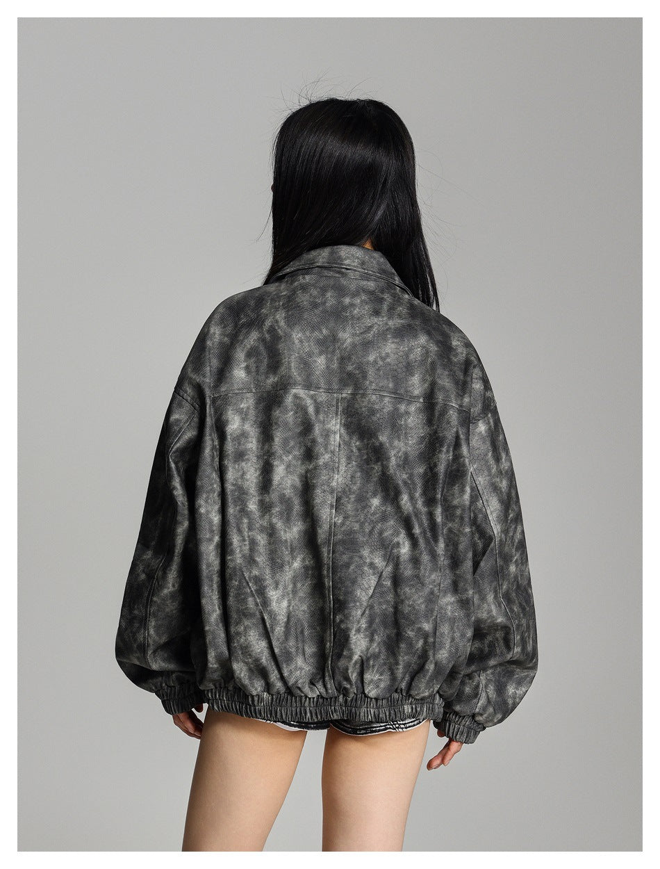 Rear view of a person wearing an oversized charcoal mottled jacket with a gathered hem and cuffs.