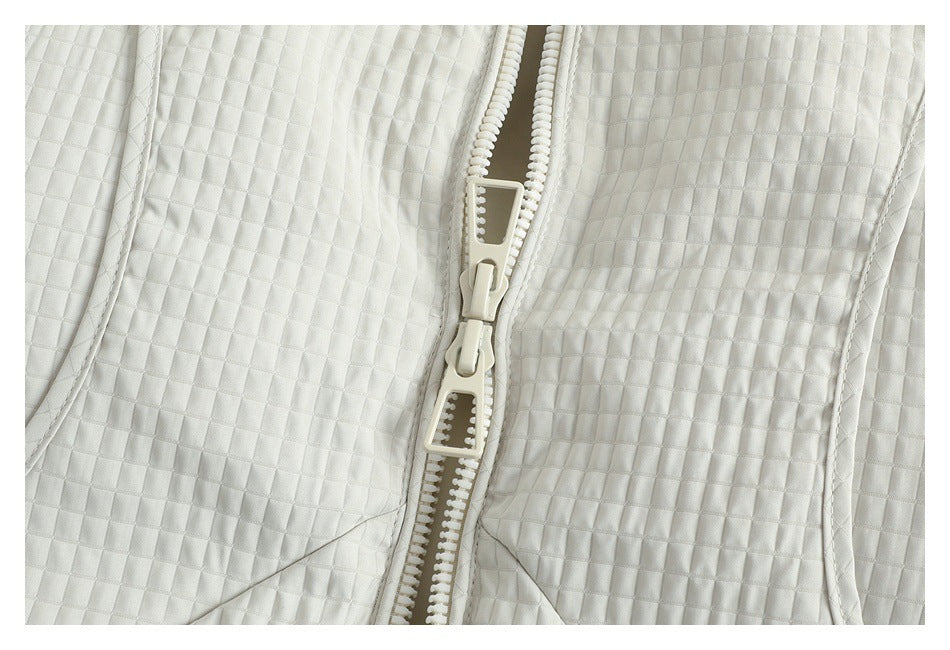 Close-up of the garment's chunky front zipper and square quilted stitching.