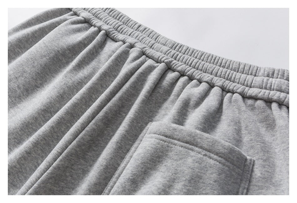 Close-up of gray heathered pants showing a gathered elastic waistband and pocket.