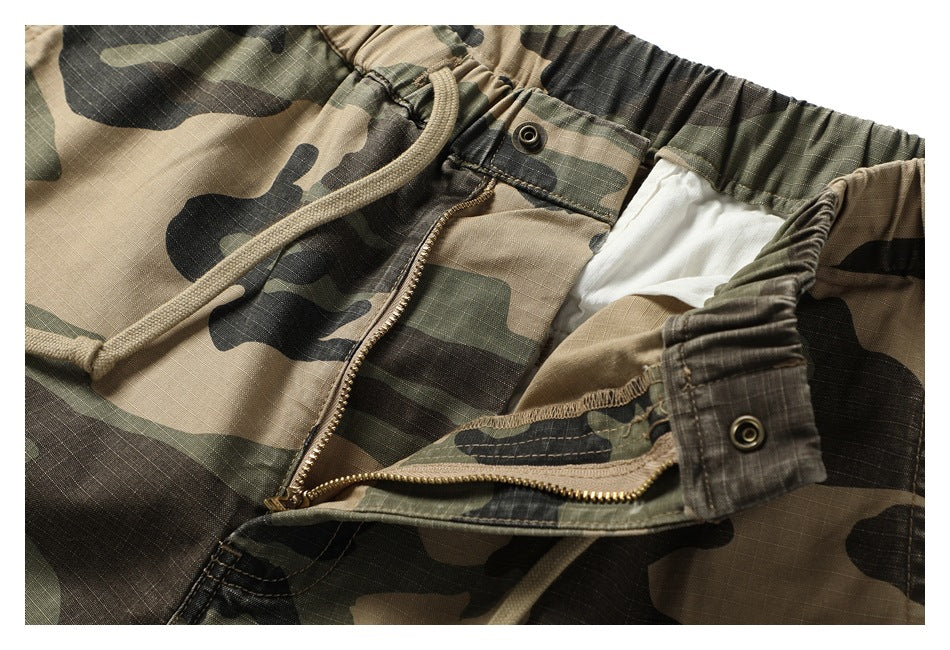 Close-up of the camouflage shorts with the front zipper and snap-fastened waistband opened.