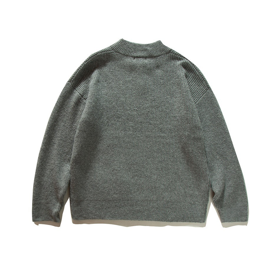 Back view of a gray-green knit sweater with a ribbed stand collar, cuffs, and hem.
