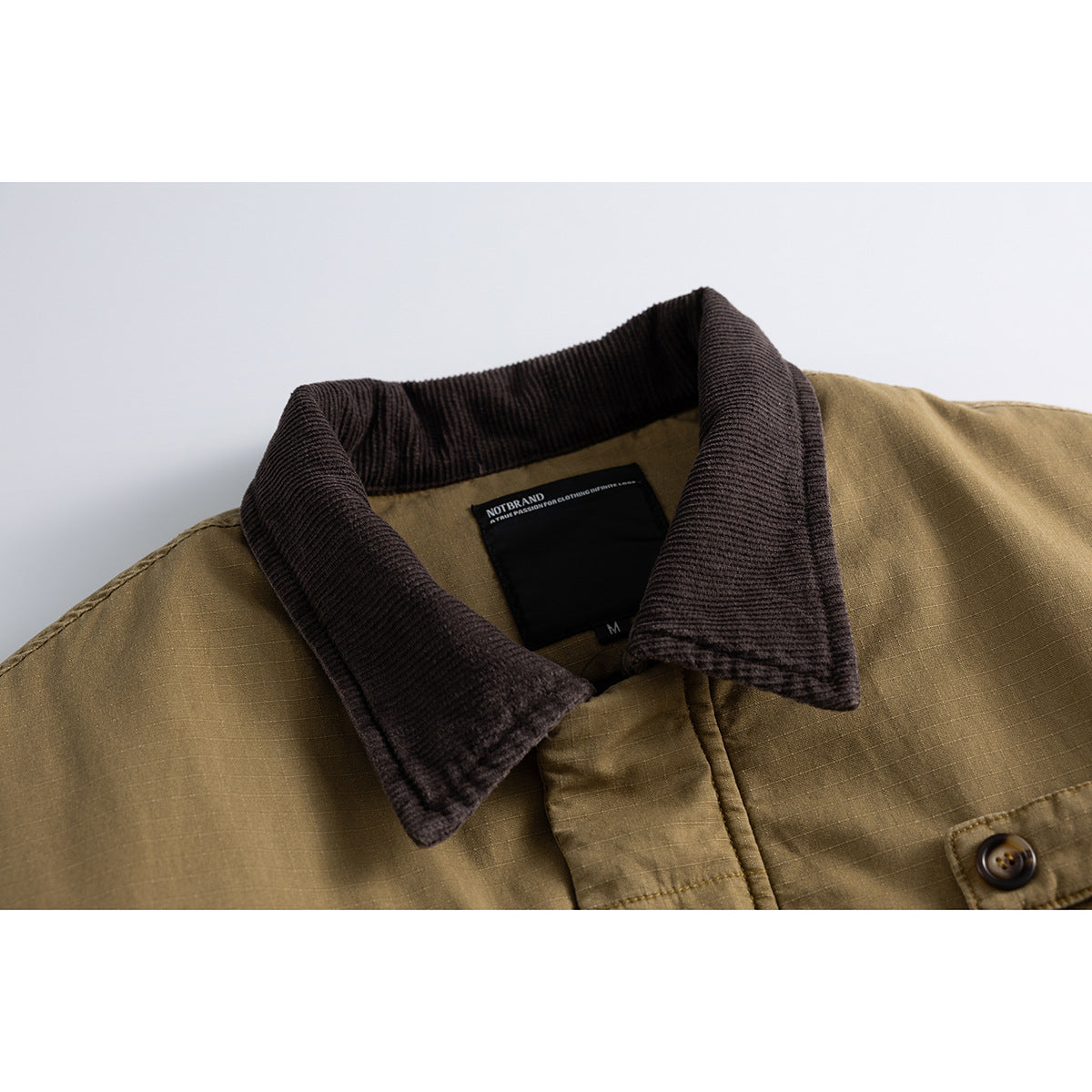 Close-up of an olive-brown jacket with a dark brown ribbed collar, button detail, and black NOTBRAND neck label.