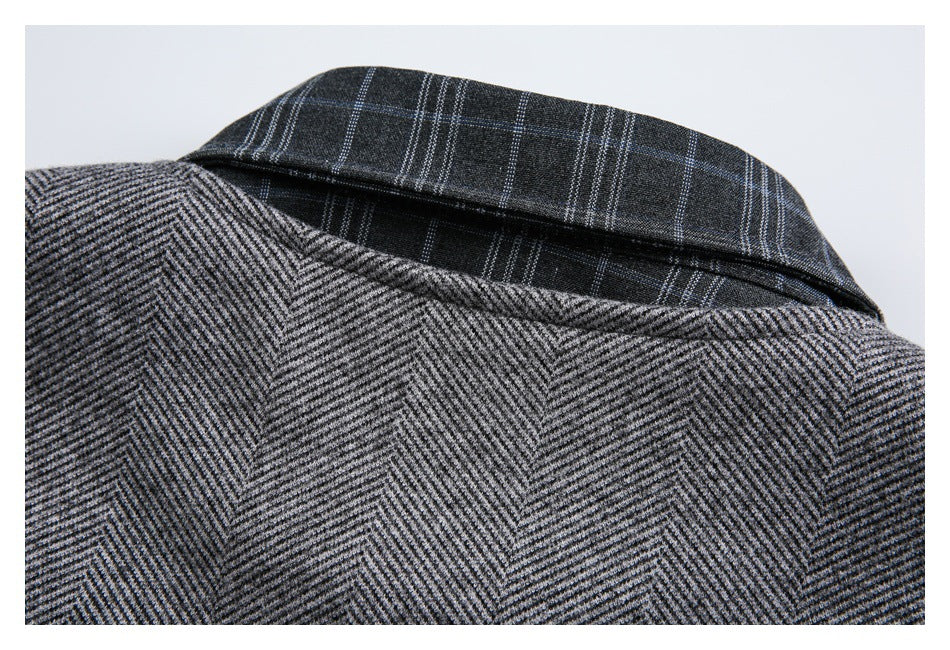 Close-up of a gray herringbone garment with a dark plaid collar.