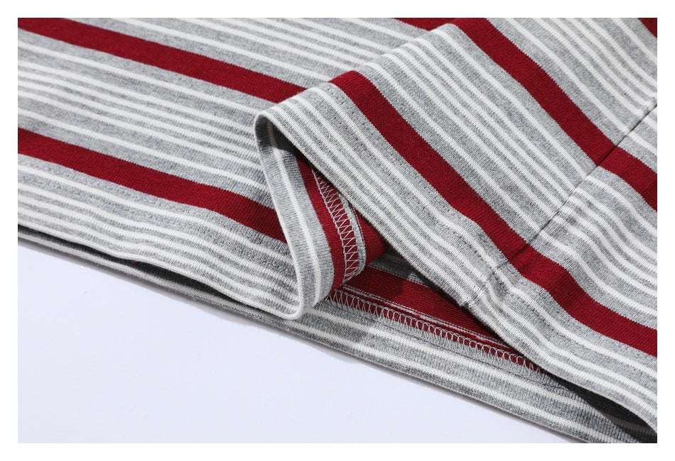 Close-up of the striped shirt's folded hem, showing the inside seam and overlock stitching.