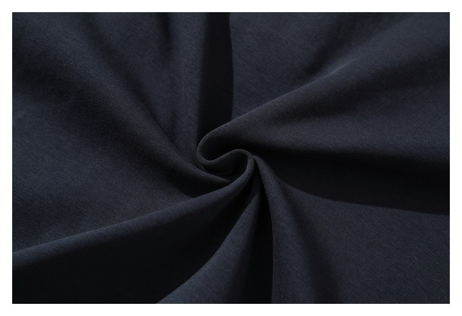 Close-up of dark navy fabric gathered into folds, showing its surface and drape.