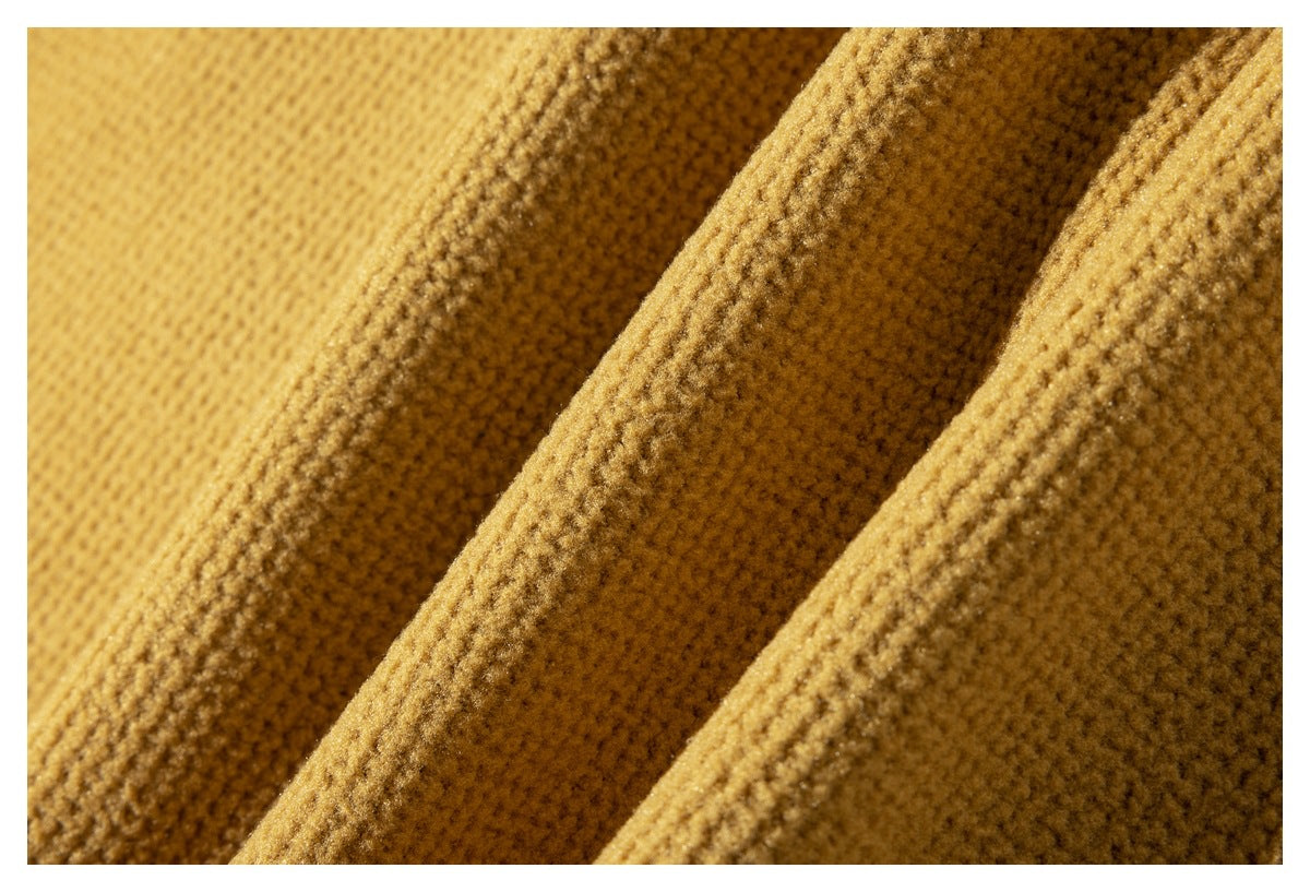 Extreme close-up of the mustard jacket fabric's raised, pebbled texture.