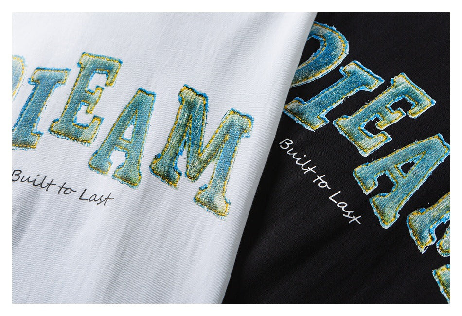 Close-up of white and black T-shirts with large blue-and-gold lettering and “Built to Last” text.