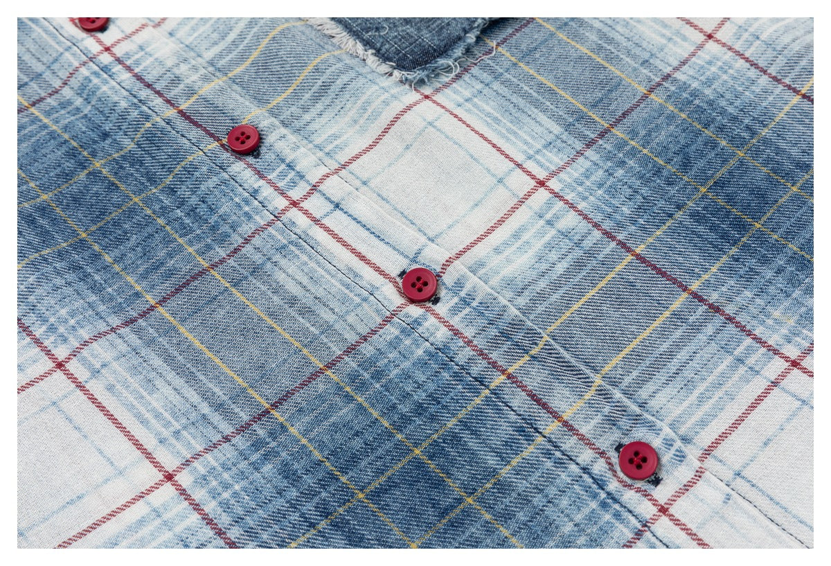 Close-up of red buttons and plaid fabric in blue, white, yellow and red.