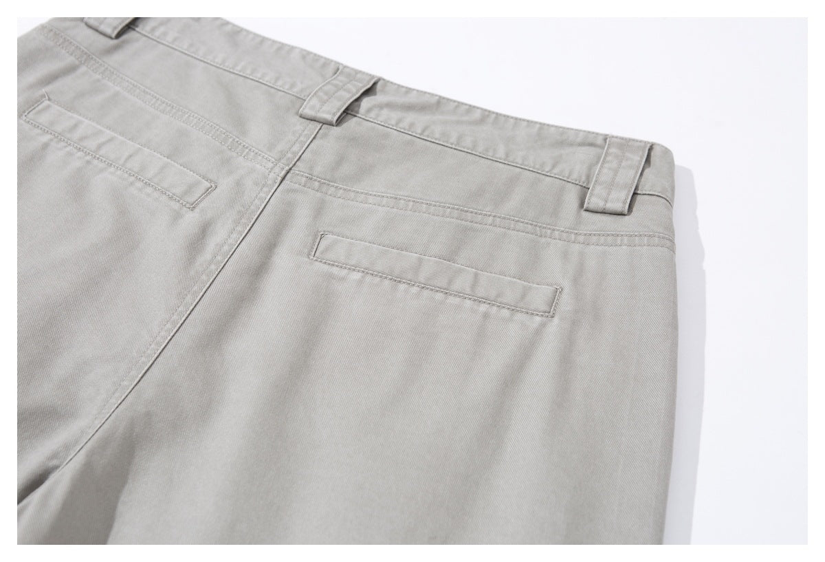 Close-up of the back of light gray trousers, showing belt loops and two welt pockets.