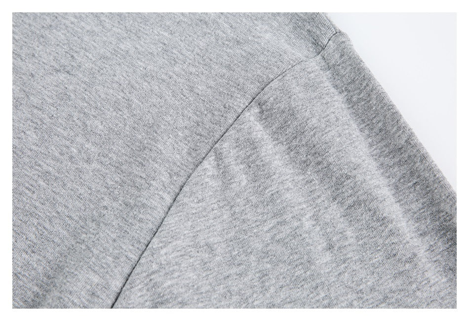 Close-up of a gray heather sweatshirt sleeve and curved shoulder seam.