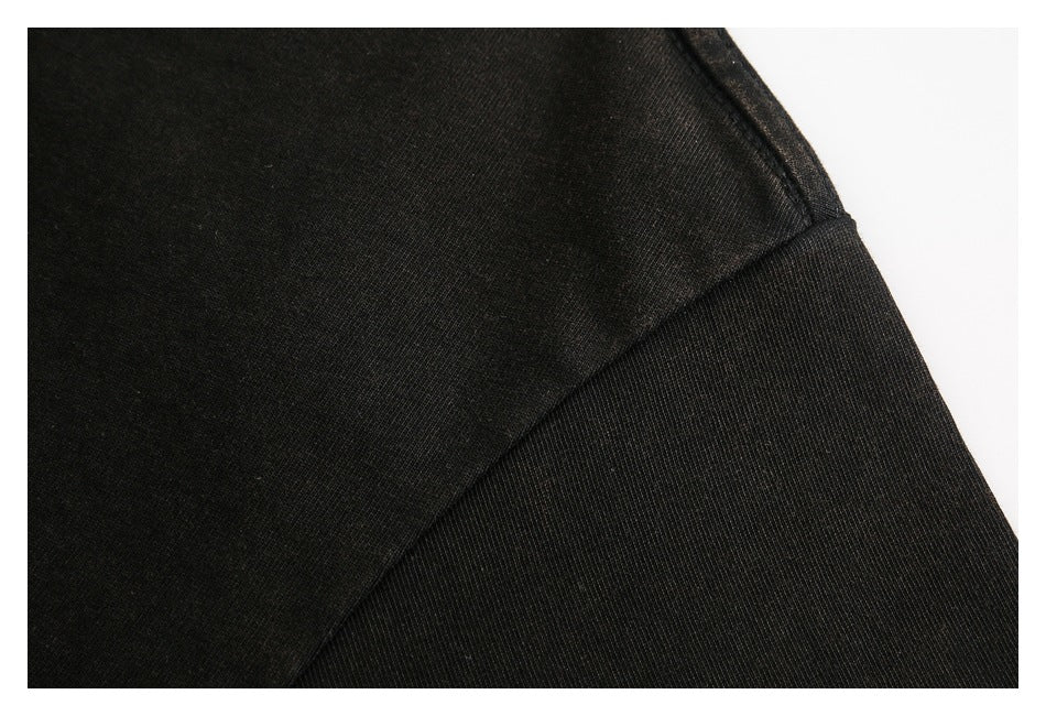 Close-up of black garment fabric and a curved stitched seam against a white background.