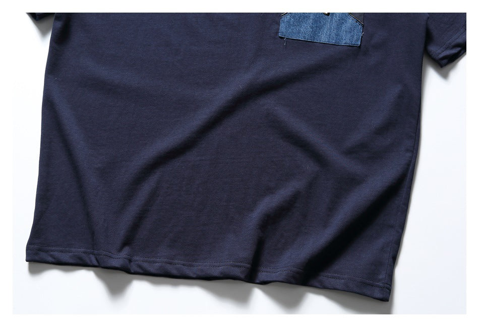 Cropped view of a navy short-sleeve shirt front with a blue patch pocket near the chest.