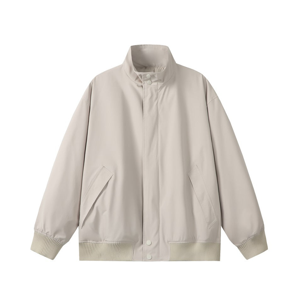 Beige stand-collar jacket flat lay, front view, with snap placket, slanted pockets and ribbed cuffs and hem