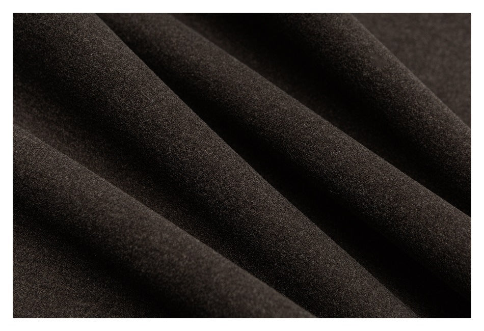 Macro view of the dark brown trouser fabric arranged in soft folds.