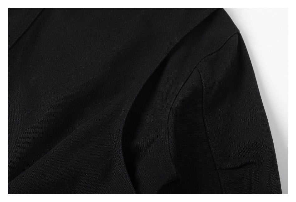 Close-up of a black garment showing a curved stitched seam and overlapping fabric panels.