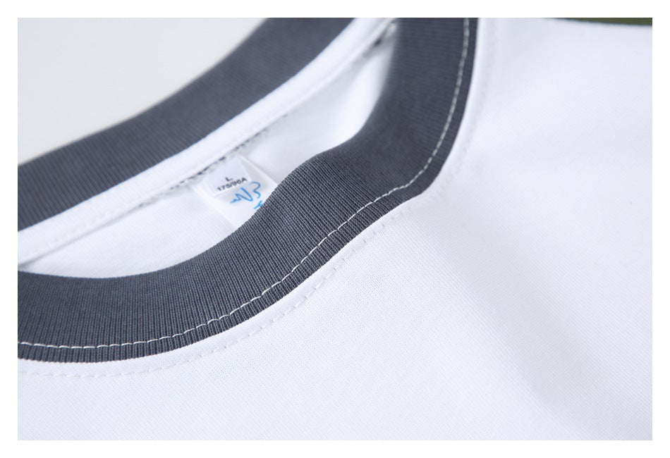 Close-up of a charcoal-gray ribbed crew neckline with white stitching on a white shirt.