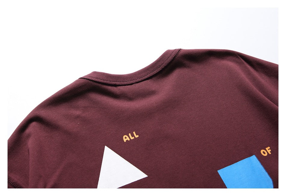 Close-up of the burgundy shirt's back neckline and part of its geometric print with yellow lettering.