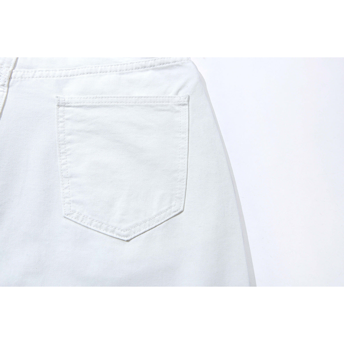 Close-up of the back of white pants, focused on a single stitched rear pocket.