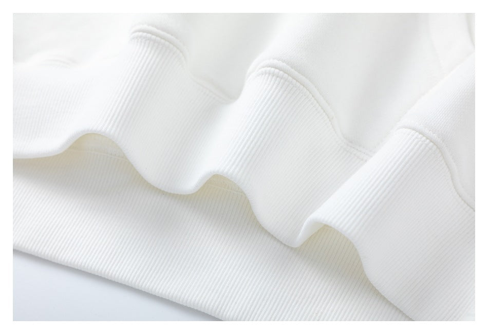 Close-up of a white garment's wide ribbed hem and stitched seam.