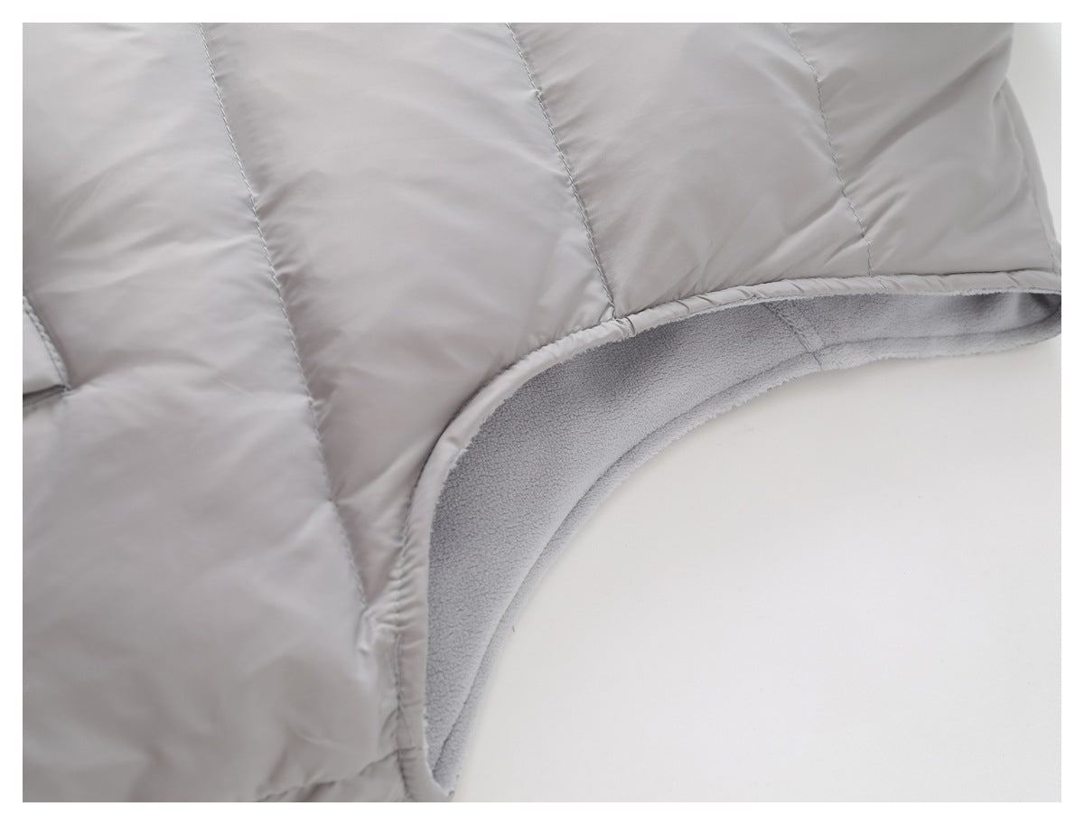 Close-up of the vest's curved armhole edge, showing the soft gray lining and quilted outer panels.
