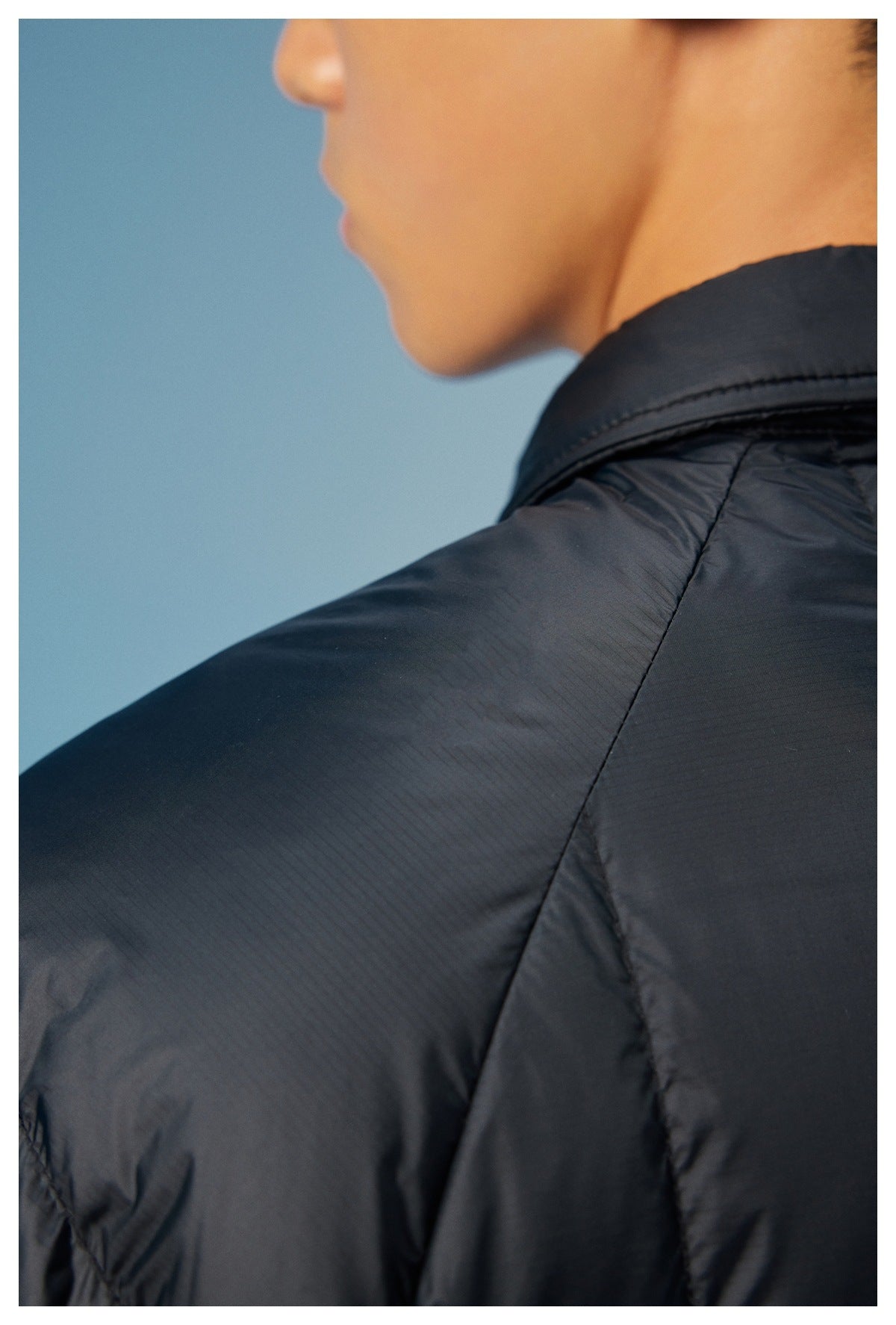 Close-up of the black jacket's collar, shoulder seam, and quilted fabric.