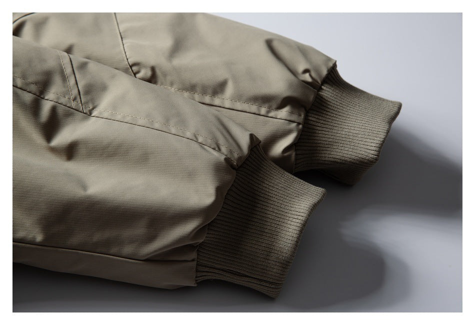 Close-up of a taupe jacket sleeve with ribbed knit cuffs and visible stitching.