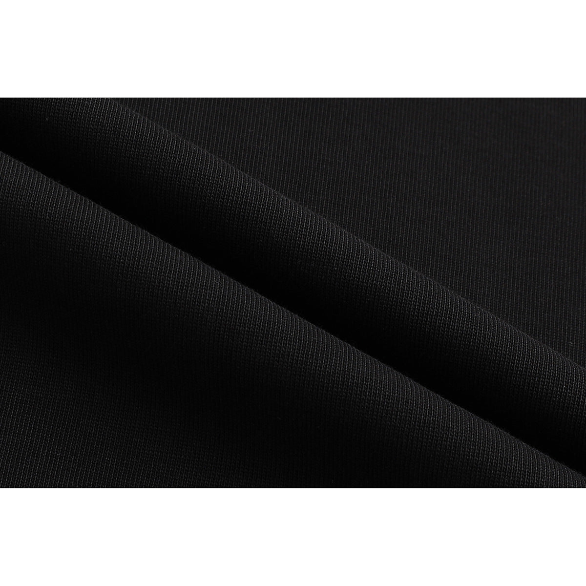 Close-up of black T-shirt fabric folded to show its surface texture.