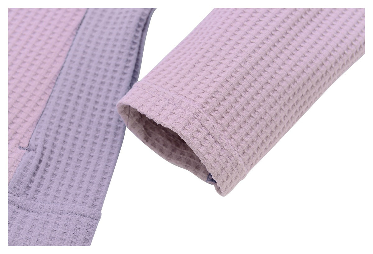 Close-up of a mauve textured jacket sleeve cuff and gray contrast panel.