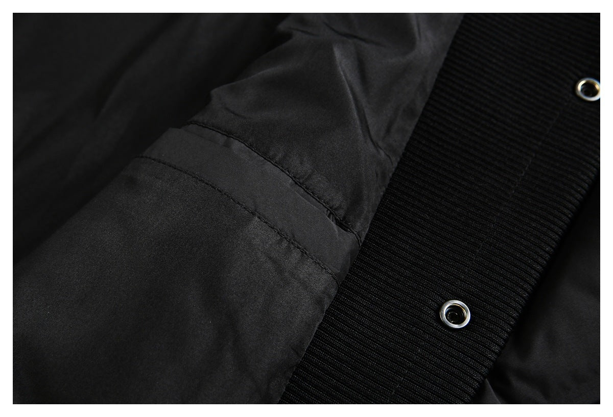 Close-up of black ribbed jacket trim with two metal-rimmed eyelets.