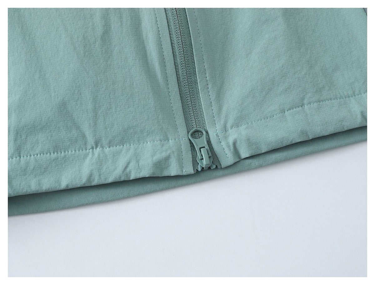 Close-up of the pale teal jacket hem and front zipper ending.