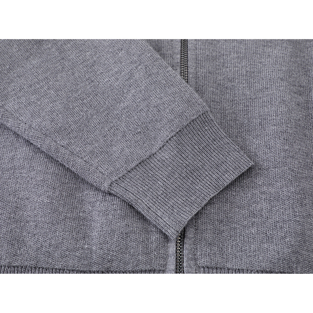 Close-up of a gray knit jacket sleeve and ribbed cuff beside the front zipper.
